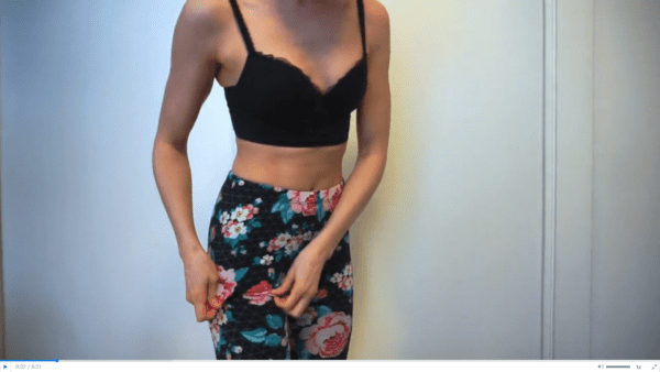 woman wearing black bra and flower leggings doing a panty try on