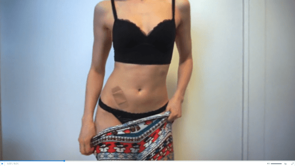woman wearing black bra and black panties removing patterned leggings in panty try on